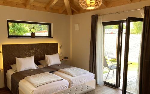 Schlafzimmer mit einem Bett und einer Glasschiebetür in der Unterkunft TS Apartments in Traunstein