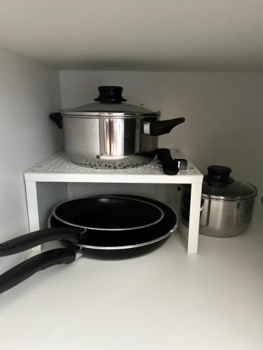 a stove with a pot and pans on a shelf at Skandi Appartments in Saldus city center in Saldus