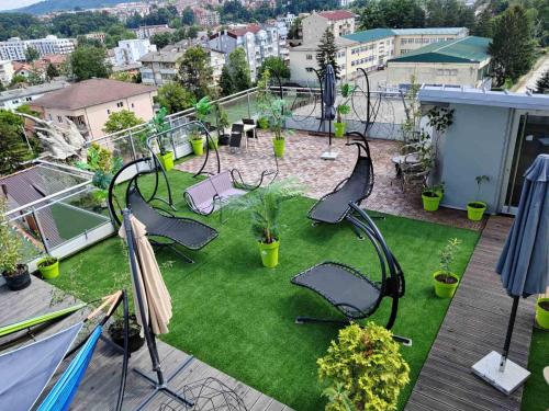 a patio with chairs and grass on a balcony at Apartman Iris in Vrnjačka Banja
