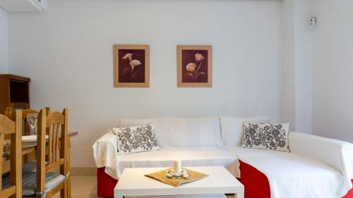 een woonkamer met een witte bank en een kaars op een tafel bij Viborilla Apartment Malaga in Málaga
