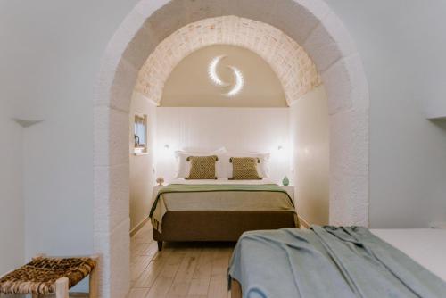 een slaapkamer met een bed in een kamer met een boog bij Il Trullo delle Due Lune in Noci