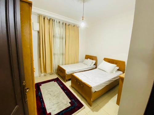 a small room with two beds and a window at شقه مفروشة الجبيهه in Amman