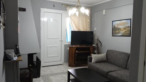 a living room with a couch and a television at Nefeli Maisonette in Nikiti