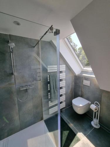 a bathroom with a glass shower and a toilet at FeWo Monika in Schaprode