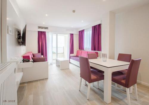 a dining room with a table and chairs and a living room at Apartamentos Ponent in Paguera