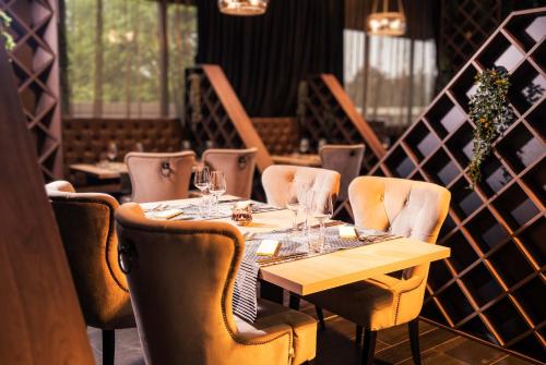 uma sala de jantar com uma mesa de madeira e cadeiras em Admiral Hotel em Zagreb