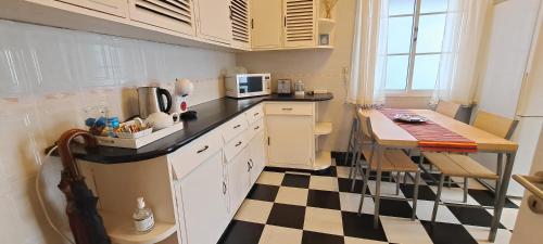 a kitchen with a black and white checkered floor at Chalé Funchal - City view in Funchal