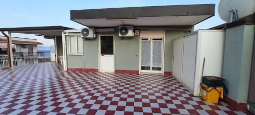 a building with a checkered floor in front of it at Timone in Roccalumera