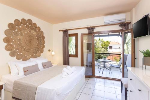una camera con letto e un balcone con tavolo di Hotel Magdalena a Pefkohori