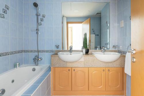 y baño con 2 lavabos, bañera y espejo. en Frank Porter - Marina Terrace, en Dubái