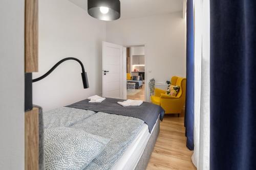 - une chambre avec un lit et une chaise jaune dans l'établissement ALFA 09, à Włocławek