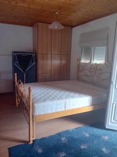 a bedroom with a large bed with a wooden frame at Vasiliki in Dhílesi