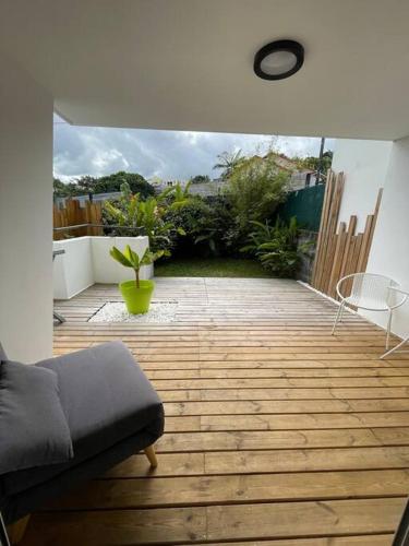 a patio with a couch and a wooden floor at Kazanoo in Le Tampon