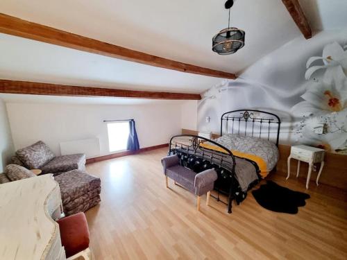 Cette grande chambre comprend un lit et un canapé. dans l'établissement l'Escapade Charentaise, à Mons