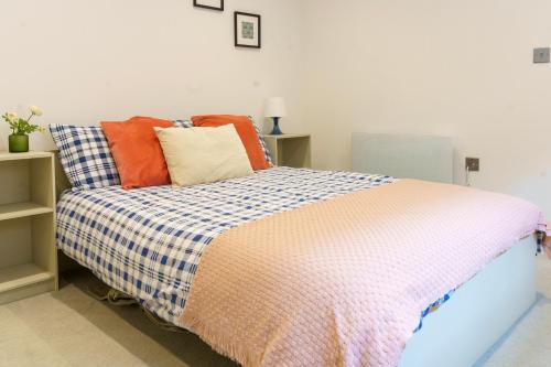 1 dormitorio con 1 cama con almohadas coloridas en Gorgeous New 2 Bed Flat - 2 August House en Londres