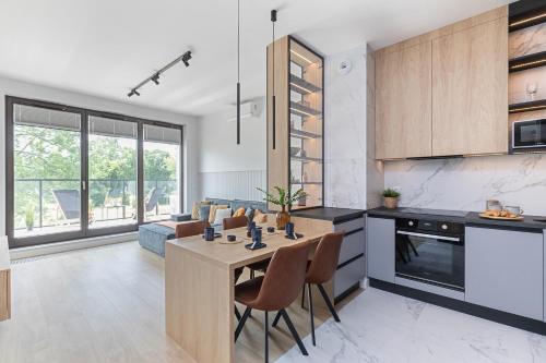 a kitchen and living room with a table and chairs at SuperApart St. Augusta 71 in Warsaw