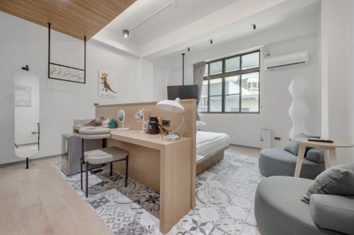 a bedroom with a desk and a bed in a room at Long Stay Here in Tainan