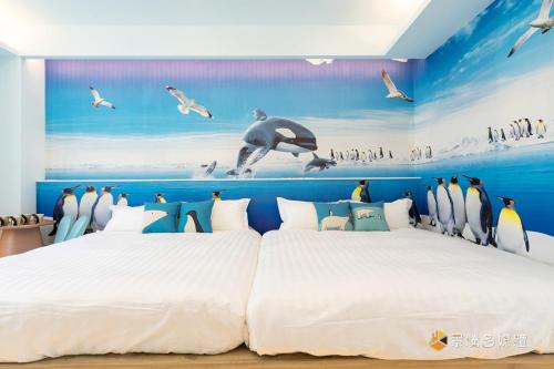 1 dormitorio con 1 cama grande con pingüinos en la pared en 武暖Zoo親子民宿（新館） en Yilan City