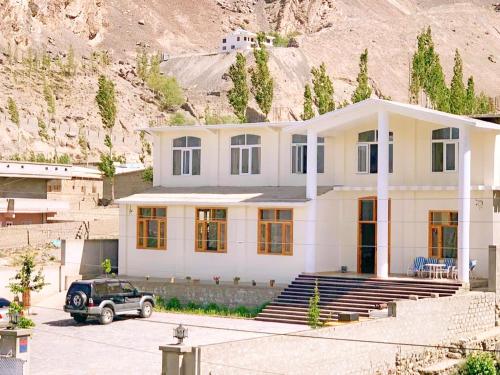 een huis met een auto ervoor geparkeerd bij Hispar Hotel Skardu in Skardu