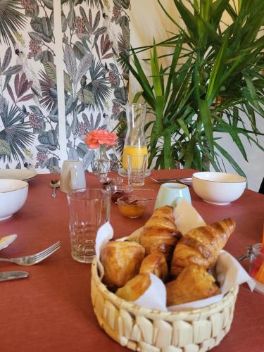 a basket of bread and pastries on a table at Chambre d'hôtes LE FLACON DE LA VERROUILLE in Bruniquel