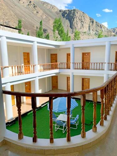 a balcony of a building with a table and chairs at Hispar Hotel Skardu in Skardu