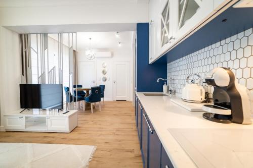 uma cozinha com paredes azuis e brancas e uma mesa em Lake Rental Spacerowa em Mikolajki