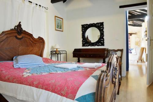 ein Schlafzimmer mit einem Bett, einem Spiegel und einem Klavier in der Unterkunft Cosy gîte with magnificent view, private terrace and shared swimming pool in Peyzac-le-Moustier