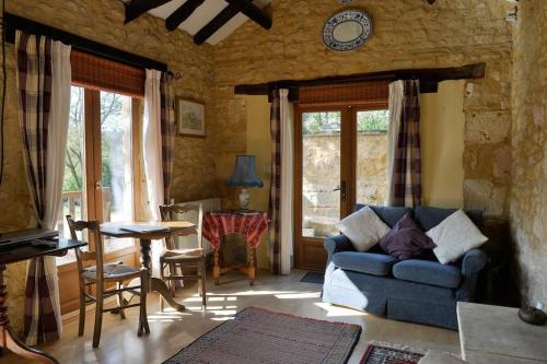ein Wohnzimmer mit einem blauen Sofa und einem Tisch in der Unterkunft Cosy gîte with magnificent view, private terrace and shared swimming pool in Peyzac-le-Moustier