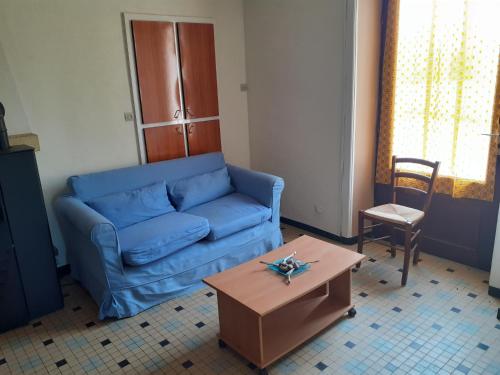 un soggiorno con divano blu e tavolo di LA CHAPELLE AUX LYS a La Chapelle-aux-Lys