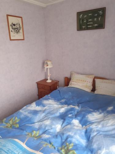una camera da letto con un piumone blu su un letto di LA CHAPELLE AUX LYS a La Chapelle-aux-Lys