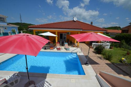 a house with a pool and two umbrellas at Mari House in Kanfanar
