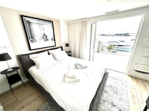 une chambre avec un lit avec des draps blancs et une fenêtre dans l'établissement Villa - Maison 10 pers - Cap d'agde - Cap Dream's - 4 Etoiles, au Cap d'Agde