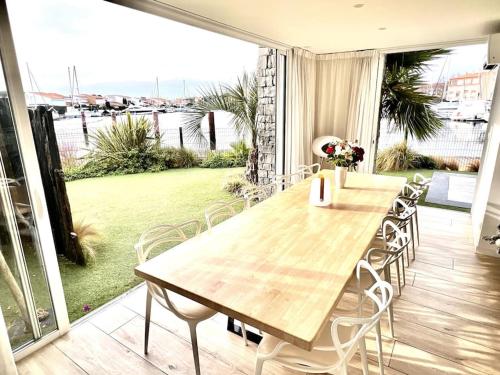 Cette chambre dispose d'une terrasse avec une table et des chaises en bois. dans l'établissement Villa - Maison 10 pers - Cap d'agde - Cap Dream's - 4 Etoiles, au Cap d'Agde