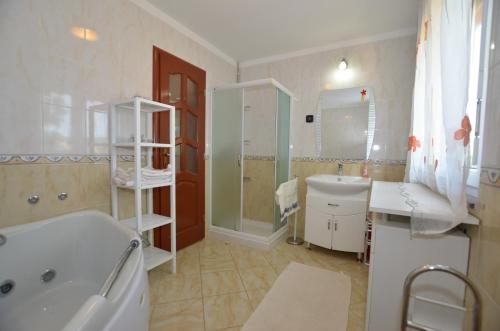 ein Bad mit einer Badewanne, einem Waschbecken und einer Dusche in der Unterkunft Mari House in Kanfanar