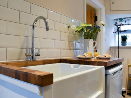 a kitchen with a large white sink in a kitchen at Corner Cottage in Great Longstone