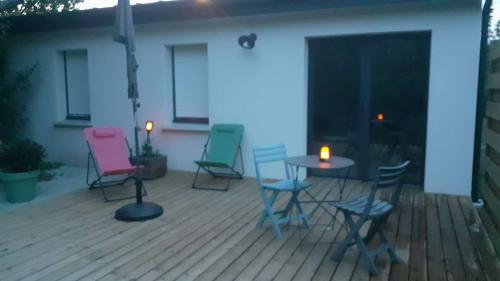 un groupe de chaises et une table sur une terrasse dans l'établissement Petite maison ensoleillée à 10 minutes du port de Vannes, à Vannes