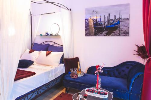 1 dormitorio con 1 cama azul y 1 sofá azul en Le Charme Martégal Suite/Spa en Martigues