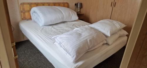 a bed with white sheets and pillows on it at 2 bed 36 Highbury park Skegness ingoldmells caravan in Ingoldmells