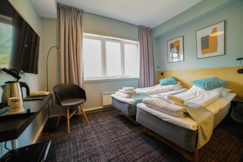 Cette chambre comprend deux lits et un bureau. dans l'établissement Sitla Hotel & Appartments, à Øvre Årdal