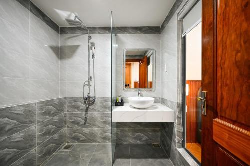 a bathroom with a sink and a shower at PLUS VUNG TAU HOTEL in Vung Tau