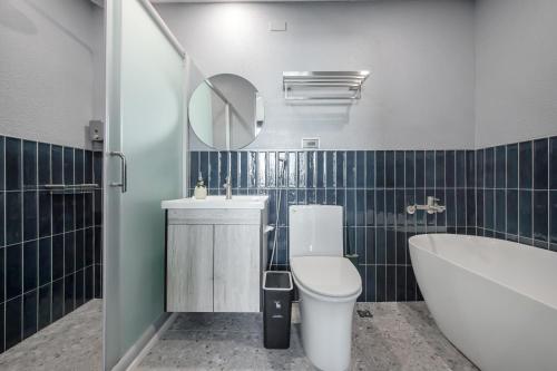a bathroom with a toilet and a tub and a sink at Long Stay Here in Tainan