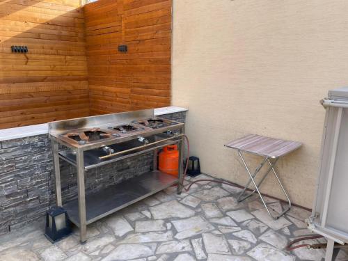 a barbecue grill sitting next to a wall with a stool at إستراحة الدنيس الونيس in Riyadh