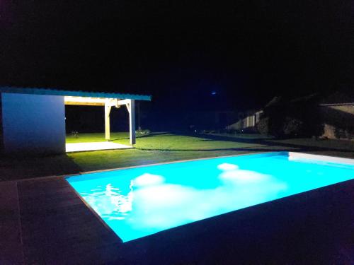 a swimming pool lit up at night at Le Poutic gîte et maison d'hôtes in Créon-dʼArmagnac
