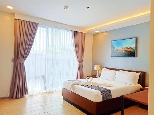 um quarto de hotel com uma cama e uma grande janela em INNCITY HOTEL em Calbayog