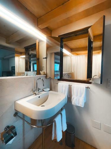 a bathroom with a white sink and a mirror at Case di Sotto, House & Breakfast in Locarno