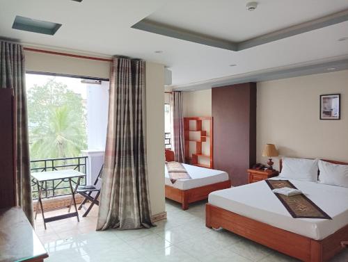 a hotel room with two beds and a balcony at Sunny B Hotel in Hue