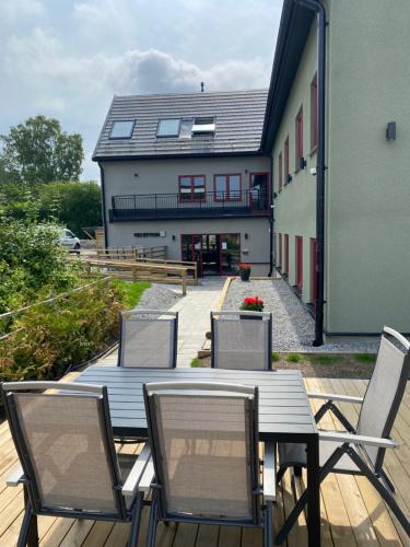 a deck with a table and chairs and a building at Magnolia House Sollentuna in Sollentuna