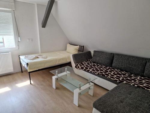 a living room with a couch and a bed at Ferienwohnungen Löwe in Kämpfelbach
