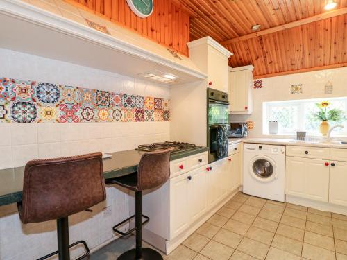 a kitchen with a counter and a washer and dryer at Elm Tree Cottage in Melton Mowbray