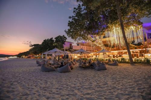 a beach with chairs and umbrellas on the sand at Sai Kaew Beach Resort in Ko Samed